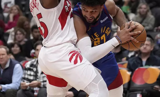 Denver Nuggets guard Jamal Murray (27) drives into Toronto Raptors guard Davion Mitchell, left, during second-half NBA basketball game action in Toronto, Monday, Oct. 28, 2024. (Nathan Denette/The Canadian Press via AP)