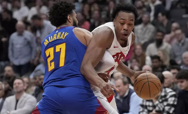 Toronto Raptors forward Scottie Barnes, right, drives into Denver Nuggets guard Jamal Murray (27) during first-half NBA basketball game action in Toronto, Monday, Oct. 28, 2024. (Nathan Denette/The Canadian Press via AP)