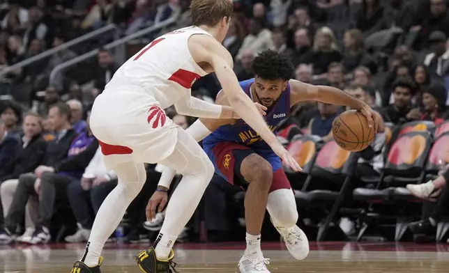 Toronto Raptors guard Gradey Dick (1) covers Denver Nuggets guard Jamal Murray, right, during second-half NBA basketball game action in Toronto, Monday, Oct. 28, 2024. (Nathan Denette/The Canadian Press via AP)