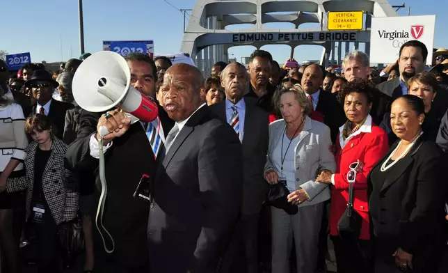 FILE - U.S. Rep. John Lewis, D-Ga., center, talks with those gathered, including Ethel Kennedy, center, and Rev. Jesse Jackson, on the historic Edmund Pettus Bridge during the 19th annual reenactment of the "Bloody Sunday" Selma to Montgomery civil rights march across the bridge in Selma, Ala., Sunday, March 4, 2012, 47 years after the historic march that led to the Voting Rights Act. (AP Photo/Kevin Glackmeyer, File)