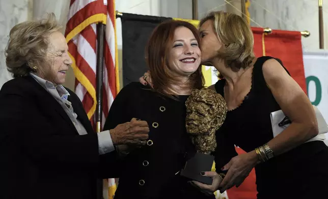 FILE - Egyptian human rights attorney and women's rights activist Ragia Omran, center, gets a kiss on the cheek from Robert F. Kennedy Center President Kerry Kennedy, right, accompanied by Ethel Kennedy, left, during the presentation of the RFK Human Rights Award, Nov. 21, 2013, on Capitol Hill in Washington. (AP Photo/Susan Walsh, File)