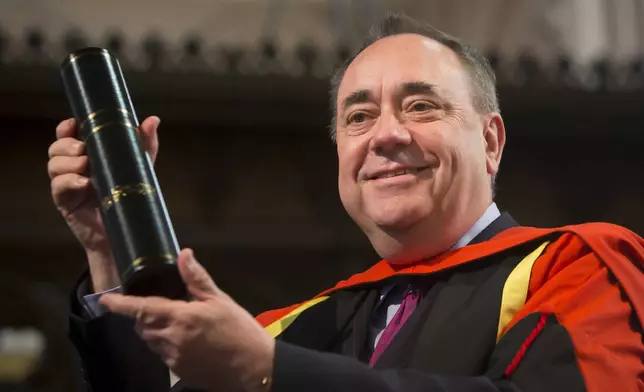 FILE - Alex Salmond holds his honorary degree awarded to him by Glasgow University on April 4, 2021. (Danny Lawson/PA via AP)