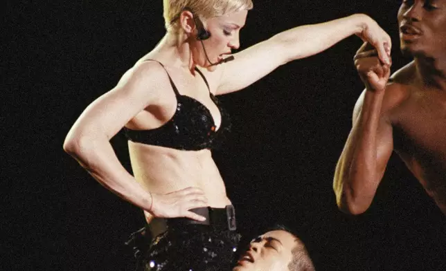 FILE - American pop star Madonna performs "Fever" in her 1993 Girlie Show World Tour concert before 30,000 fans at the Tokyo Dome, Japan, Dec. 13, 1993. (AP Photo/Koji Sasahara, File)