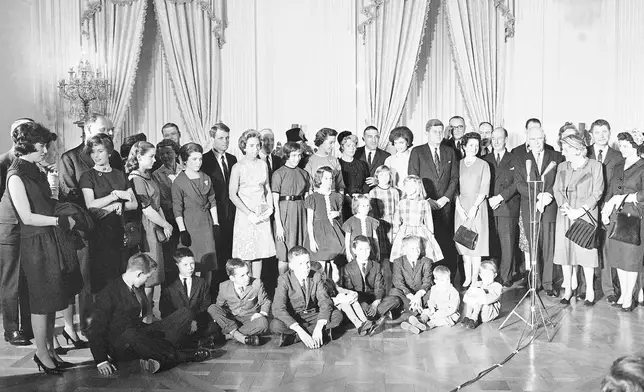 FILE - Children of three cabinet offices fill the foreground as President John Kennedy and Mrs. Jacqueline Kennedy pose with guests at a White House reception in the East Room, Jan 21, 1961. The children are those of Attorney General Robert Kennedy, Postmaster General Edward Day, and Interior Secretary Stewart Udall. Seated on floor, from left: Joe Kennedy, 8, Jimmy Day, 12, Bobby Kennedy, 6, Scott Udall, II, Tommy Udall, 12, Michael Kennedy, 2, and David Kennedy, 5. Four girls at center, from left; Kathleen Kennedy, 9, Courtney Kennedy, 4, Lynn Udall, 10, and Lori Udall, 8. Back row: Robert Kennedy, his wife Ethel, Edward Day, Molly Day, 14, and Mrs. Day. Hidden: Geraldine Day, 17; Mrs. Irma Udall, the First Lady, the president, Vice President Johnson, Mrs. Lady Bird Johnson, Frederick Dutton of White House staff and Adlai Stevenson, ambassador to the United Nations. (AP Photo/William Allen, File)