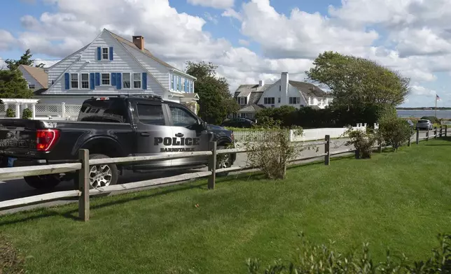 A Barnstable Police truck is stationed at the entrance to Marchant Ave. at the entrance to the Kennedy compound, Thursday, Oct. 10, 2024, in Hyannis, Mass., to provide security following the announcement of the death of Ethel Kennedy, whose home is at background right. (Steve Heaslip/Cape Cod Times via AP)