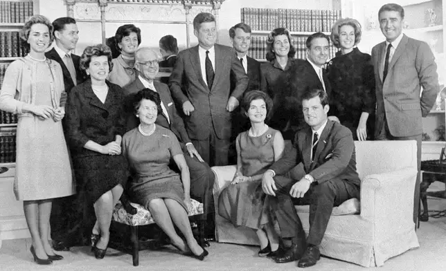 FILE - Then President-elect John F. Kennedy, standing at center, is surrounded by members of his family in the home of his parents in December 1960, in Hyannis Port, Mass. Standing, Ethel Kennedy, from left, wife of Robert Kennedy, Steven Smith and wife Jean Kennedy Smith, Robert Kennedy, Patricia Kennedy Lawford, Sargent Shriver, Joan Kennedy, wife of Edward Kennedy, and Peter Lawford, and in foreground, Eunice Kennedy Shriver, from left, Joseph P. Kennedy and wife Rose Kennedy, seated in front, Jacqueline Kennedy, and Edward Kennedy. (AP Photo, File)