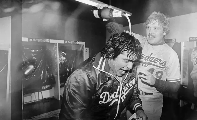 FILE - Los Angeles Dodgers pitcher Fernando Valenzuela is doused with champagne by teammate Tom Niedenfuer after the Dodgers won the National League title over the Expos, Oct. 20, 1981, in Montreal. Fernando Valenzuela, the Mexican-born phenom for the Los Angeles Dodgers who inspired “Fernandomania” while winning the NL Cy Young Award and Rookie of the Year in 1981, has died Tuesday, Oct. 22, 2024.(AP Photo/MacAlpine, File)