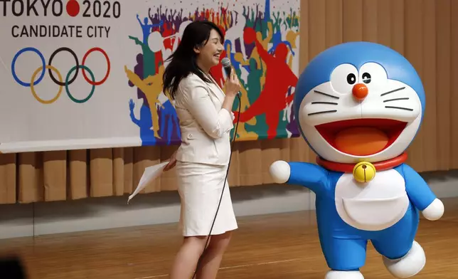 FILE - Doraemon, one of the most popular animation characters in Japan, participates in a kick-off ceremony of the Tokyo's bid to host the 2020 Olympics in Tokyo when Tokyo is bidding against Istanbul and Madrid to host the 2020 Olympics on Aug. 23, 2013. (AP Photo/Koji Sasahara, File)