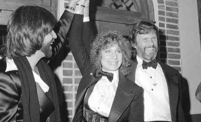 FILE - Producer Jon Peters, from left, Barbra Streisand and Kris Kristofferson appear at a preview of the film, "A Star is Born," in Dec. 23, 1976, in New York. Kristofferson, a Rhodes scholar with a deft writing style and rough charisma who became a country music superstar and A-list Hollywood actor, has died Saturday, Sept. 28, 2024. (AP Photo/Suzanne Vlamis, File)