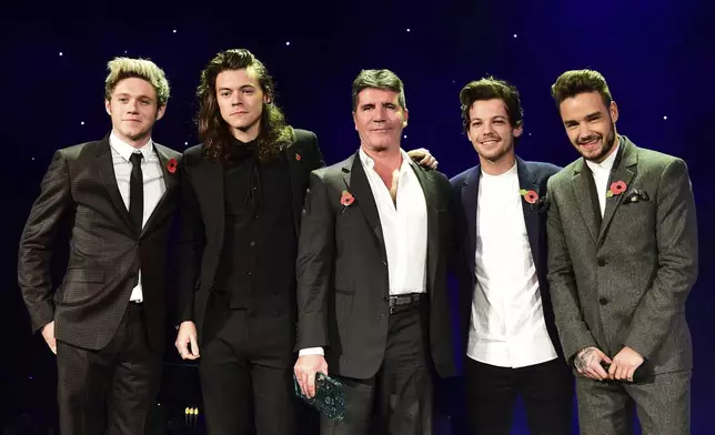 FILE - One Direction's Niall Horan, from left, Harry Styles , Simon Cowell, Louis Tomlinson and Liam Payne present the Music Industry Trust Award to Simon Cowell at the Music Industry Trusts Award (MITS) in aid of charities Nordon Robbins and Brit Trust at the Grosvenor House Hotel, in London, Nov. 2, 2015. (Dominic Lipinski/PA via AP)