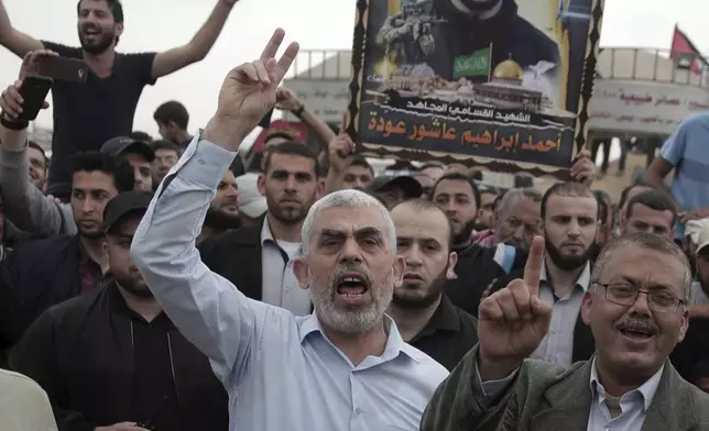 FILE - Hamas leader in the Gaza Strip, Yahya Sinwar, center, chant slogans as he surrounded by protesters during his visit to the Gaza Strip's border with Israel, on April 20, 2018. (AP Photo/ Khalil Hamra)