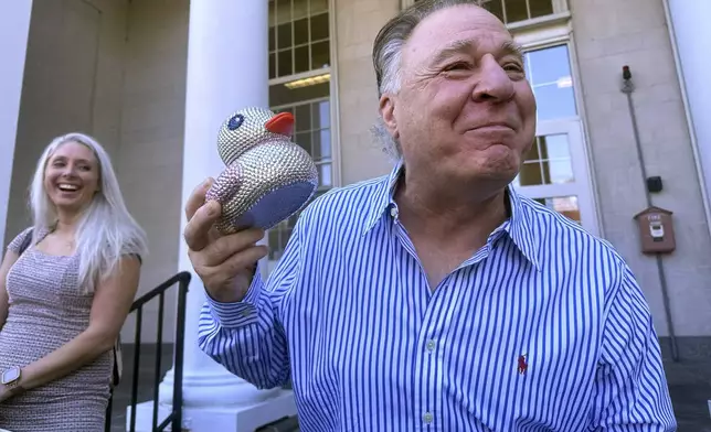 Richard Schiffer Jr., who faces witness intimidation and other charges related to the Karen Read case, holds a duck as he greets greets supporters on the steps outside Stoughton District Court following his arraignment, Wednesday, Oct. 23, 2024 in Stoughton, Mass. (AP Photo/Michael Casey)