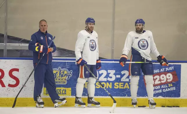 FILE - Edmonton Oilers' defensive coach Paul Coffey stands with Connor McDavid (97) and Leon Draisaitl (29) during practice in Edmonton on Thursday June 20, 2024. The Edmonton Oilers take on the Florida Panthers in game 6 of the NHL Stanley Cup final on Friday. (Jason Franson/The Canadian Press via AP, File)