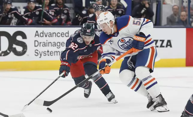 Edmonton Oilers' Troy Stecher, right, tries to skate past Columbus Blue Jackets' Mikael Pyyhtia, left, during the third period of an NHL hockey game Monday, Oct. 28, 2024, in Columbus, Ohio. (AP Photo/Jay LaPrete)