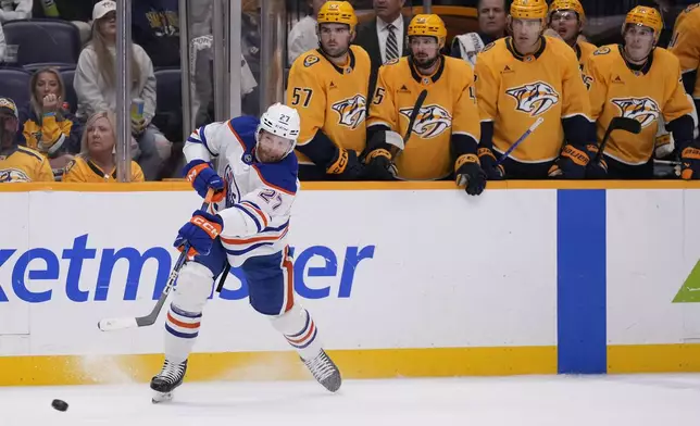 Edmonton Oilers defenseman Brett Kulak (27) shoots the puck to score an empty-net goal during the third period of an NHL hockey game against the Nashville Predators, Thursday, Oct. 17, 2024, in Nashville, Tenn. (AP Photo/George Walker IV)