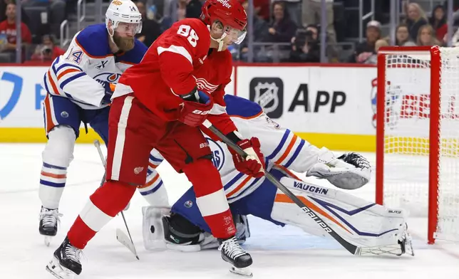 Detroit Red Wings right wing Patrick Kane (88) takes a shot on goal against Edmonton Oilers defenseman Mattias Ekholm (14) and goaltender Calvin Pickard during the second period of an NHL hockey game Sunday, Oct. 27, 2024, in Detroit. (AP Photo/Duane Burleson)