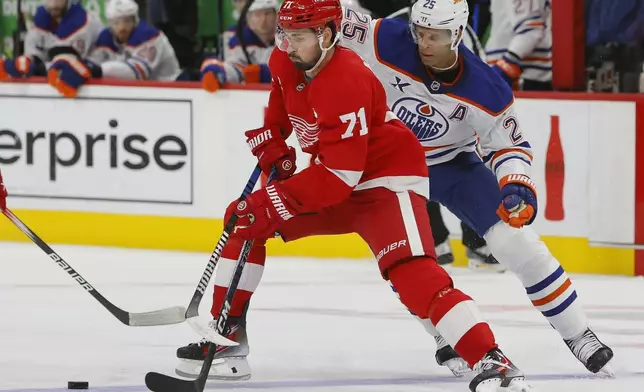 Detroit Red Wings center Dylan Larkin (71) is guarded by Edmonton Oilers defenseman Darnell Nurse (25) during the second period of an NHL hockey game Sunday, Oct. 27, 2024, in Detroit. (AP Photo/Duane Burleson)