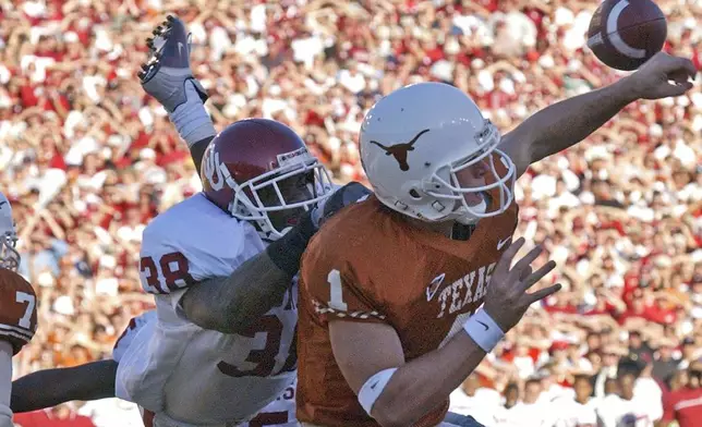 FILE - -Texas quarterback Chris Simms (1) is hit by Oklahoma's Roy Williams (38) in the fourth quarter, causing Simms to throw an interception to Oklahoma's Teddy Lehman, Saturday, Oct. 6, 2001, in Dallas. Lehman returned the interception 2 yards for a touchdown and Oklahoma won 14-3. (AP Photo/Tim Sharp, File)