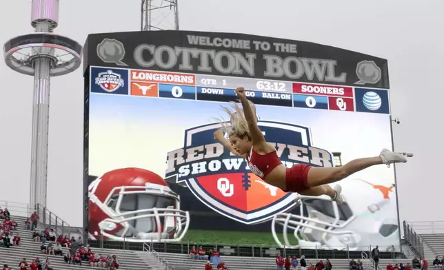 FILE - An Oklahoma cheerleader flies in the air before an NCAA college football game between Texas and Oklahoma at the Cotton Bowl, Saturday, Oct. 11, 2014, in Dallas. (AP Photo/LM Otero, File)