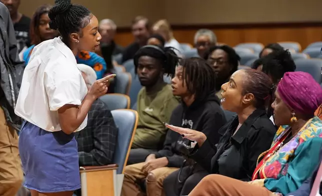 Simone Haley, granddaughter of Oretha Castle Haley, challenges Lakita Smith, seated with Candice Henderson-Chandler, after speaking during a city council hearing regarding the dispute over her grandmother's former home and plans by the property owner, Henderson-Chandler, to create a museum, in New Orleans, Thursday, Oct. 24, 2024. (AP Photo/Gerald Herbert)