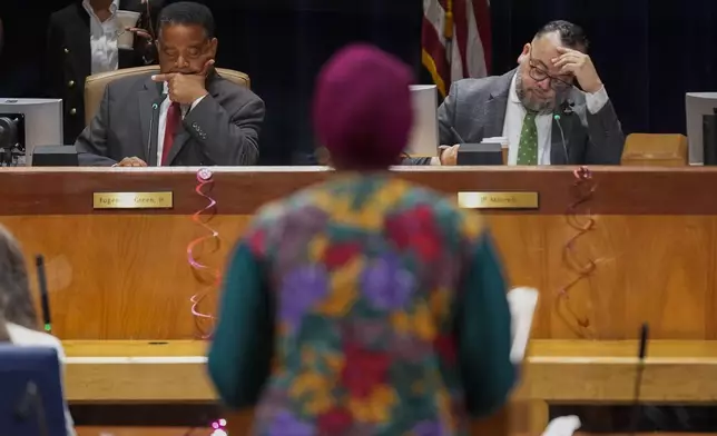 New Orleans city council members Eugene J. Green, left, and JP Morrell, listen as Candice Henderson-Chandler, who purchased the former home of civil rights leader Oretha Castle Haley and plans to open a museum, speaks during a city council hearing on the matter, which is opposed by Castle Haley's family, in New Orleans, Thursday, Oct. 24, 2024. (AP Photo/Gerald Herbert)