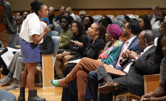 Simone Haley, granddaughter of Oretha Castle Haley, challenges Lakita Smith, seated with Candice Henderson-Chandler, after speaking during a city council hearing regarding the dispute over her grandmother's former home and plans by the property owner, Henderson-Chandler, to create a museum, in New Orleans, Thursday, Oct. 24, 2024. (AP Photo/Gerald Herbert)