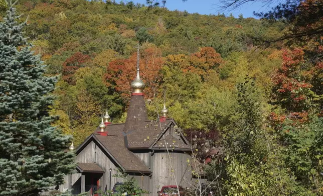 The Church of Holy Transfiguration, built by monks in 1970, is seen through fall foliage on the campus of New Skete, a Christian Orthodox monastery renowned for dog breeding and training programs outside Cambridge, N.Y., on Oct. 12, 2024. (AP Photo/Giovanna Dell’Orto)