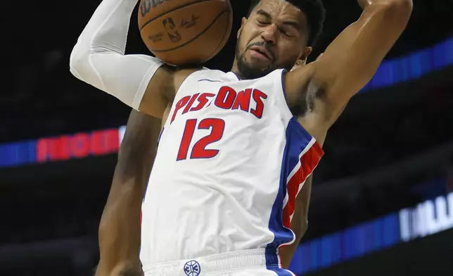 Detroit Pistons forward Tobias Harris (12) dunks past Indiana Pacers center James Wiseman during the first half of an NBA basketball game Wednesday, Oct. 23, 2024, in Detroit. (AP Photo/Duane Burleson)