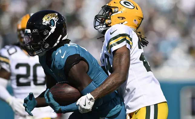 Jacksonville Jaguars' Brian Thomas Jr. catches a pass in front of Green Bay Packers' Xavier McKinney during the first half of an NFL football game Sunday, Oct. 27, 2024, in Jacksonville, Fla. (AP Photo/Phelan M. Ebenhack)