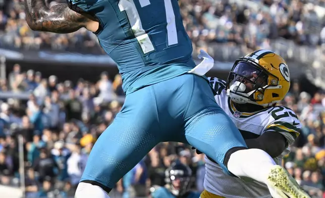 Jacksonville Jaguars' Evan Engram catches a touchdown pass over Green Bay Packers' Keisean Nixon during the second half of an NFL football game Sunday, Oct. 27, 2024, in Jacksonville, Fla. (AP Photo/Phelan M. Ebenhack)