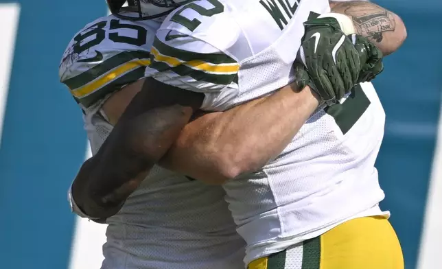 Green Bay Packers' Tucker Kraft celebrates his touchdown catch with Malik Willis (2) during the second half of an NFL football game against the Jacksonville Jaguars Sunday, Oct. 27, 2024, in Jacksonville, Fla. (AP Photo/Phelan M. Ebenhack)