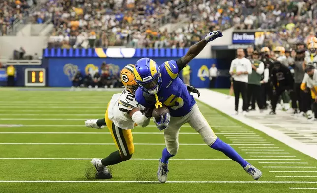 Los Angeles Rams wide receiver Tutu Atwell (5) is brought down by Green Bay Packers cornerback Carrington Valentine (24) during a two-point conversion attempt in the second half of an NFL football game Sunday, Oct. 6, 2024, in Inglewood, Calif. (AP Photo/Gregory Bull)