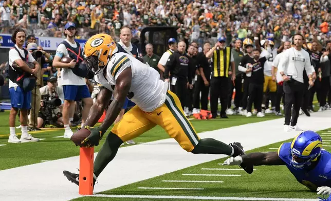 Green Bay Packers running back Josh Jacobs, left, scores a touchdown as he is defended by Los Angeles Rams linebacker Jared Verse during the first half of an NFL football game Sunday, Oct. 6, 2024, in Inglewood, Calif. (AP Photo/Gregory Bull)