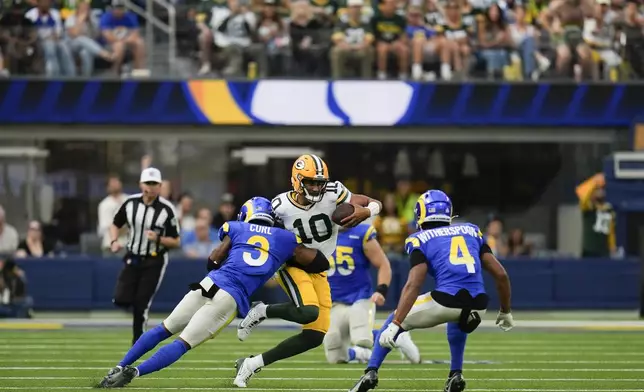 Los Angeles Rams safety Kamren Curl (3) grabs Green Bay Packers quarterback Jordan Love (10) during the second half of an NFL football game Sunday, Oct. 6, 2024, in Inglewood, Calif. (AP Photo/Gregory Bull)