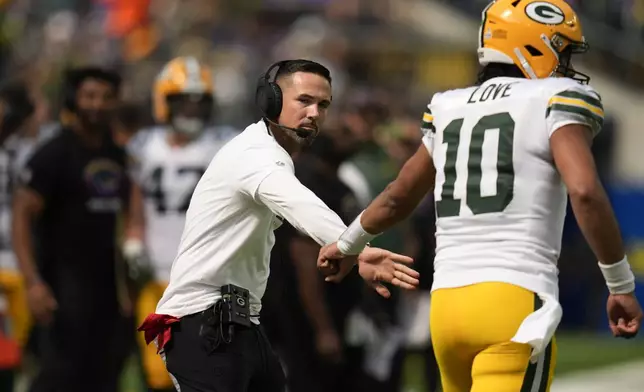 Green Bay Packers Head Coach Matt LaFleur, left, and quarterback Jordan Love (10) celebrates a touchdown by running back Josh Jacobs during the first half of an NFL football game against the Los Angeles Rams Sunday, Oct. 6, 2024, in Inglewood, Calif. (AP Photo/Gregory Bull)