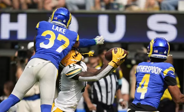 Green Bay Packers wide receiver Jayden Reed (11) makes a catch against Los Angeles Rams safety Quentin Lake (37) and cornerback Ahkello Witherspoon (4) during the first half of an NFL football game Sunday, Oct. 6, 2024, in Inglewood, Calif. (AP Photo/Gregory Bull)