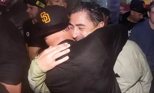 San Diego Padres manager Mike Shildt, left, celebrates with general manager A.J. Preller after the Padres clinched a playoff spot with a triple play to end their baseball game against the Los Angeles Dodgers, Tuesday, Sept. 24, 2024, in Los Angeles. (AP Photo/Mark J. Terrill)