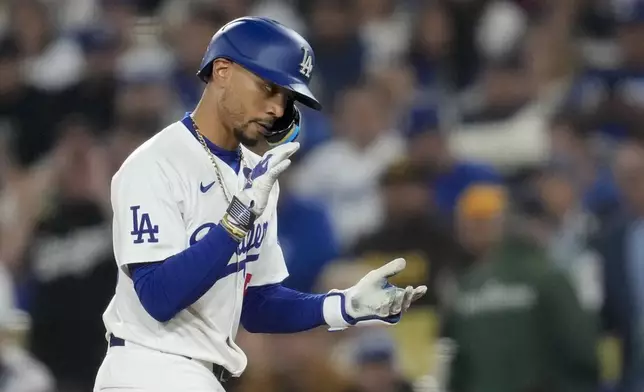 Los Angeles Dodgers' Mookie Betts celebrates after hitting a single during the first inning of a baseball game against the San Diego Padres Thursday, Sept. 26, 2024, in Los Angeles. (AP Photo/Ashley Landis)