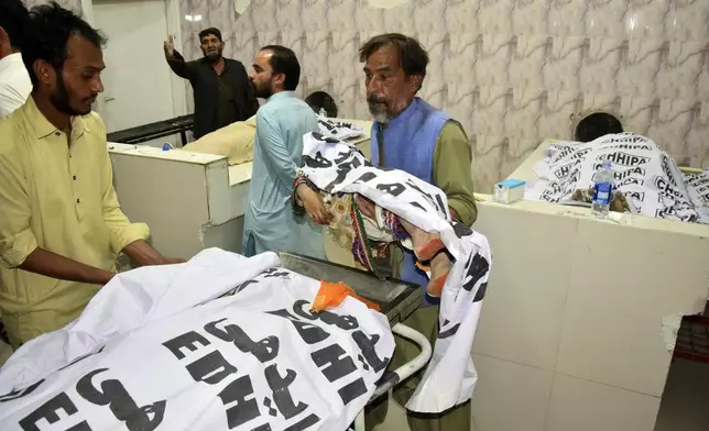 A man carries a girl killed in a bus incident, at a hospital in Quetta, the capital of Balochistan province, Pakistan, Thursday, Oct. 3, 2024. A speeding bus carrying wedding guests plunged into a ravine in southwestern Pakistan on Thursday, killing at least seven people, officials and rescuers said. (AP Photo/Arshad Butt)