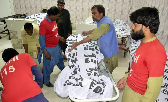 Rescue workers gather around the bodies killed in a bus accident, at a hospital in Quetta, the capital of Balochistan province, Pakistan, Thursday, Oct. 3, 2024. A speeding bus carrying wedding guests plunged into a ravine in southwestern Pakistan on Thursday, killing at least seven people, officials and rescuers said. (AP Photo/Arshad Butt)