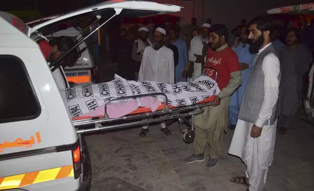 Rescue workers and relatives load the dead body into an ambulance, at a hospital in Quetta, the capital of Balochistan province, Pakistan, Thursday, Oct. 3, 2024. A speeding bus carrying wedding guests plunged into a ravine in southwestern Pakistan on Thursday, killing at least seven people, officials and rescuers said. (AP Photo/Arshad Butt)