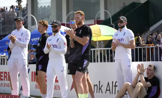 England's Ben Stokes, center, and teammates clap in an awarding ceremony on the end of third test cricket match between Pakistan and England, in Rawalpindi, Pakistan, Saturday, Oct. 26, 2024. (AP Photo/Anjum Naveed)