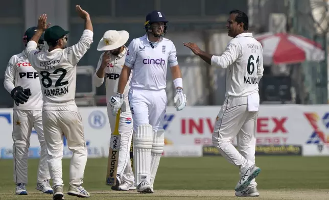 Pakistan's Noman Ali, right, celebrates after taking the wicket of England's Joe Root, second right, during the fourth day of the second test cricket match between Pakistan and England, in Multan, Pakistan, Friday, Oct. 18, 2024. (AP Photo/K.M. Chaudary)