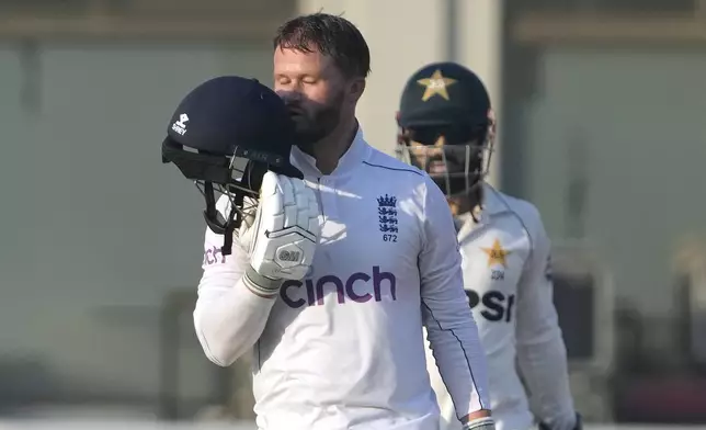 England's Ben Duckett kisses his helmet after scoring century during the second day of the second test cricket match between Pakistan and England, in Multan, Pakistan, Wednesday, Oct. 16, 2024. (AP Photo/K.M. Chaudary)