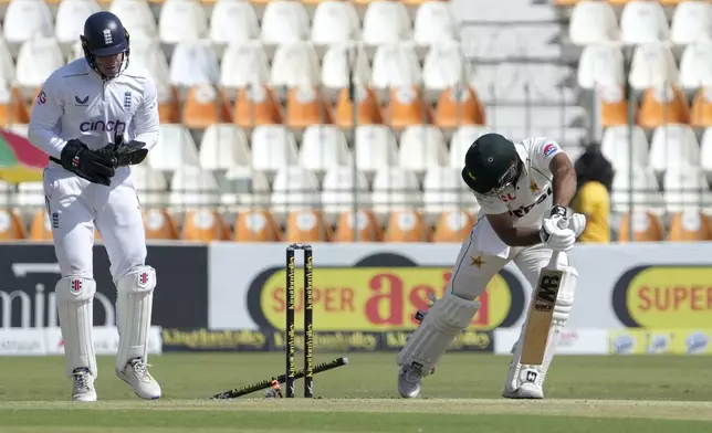 Pakistan's Abdullah Shafique, right, is bowled out by England's Jack Leach during the first day of the second test cricket match between Pakistan and England, in Multan, Pakistan, Tuesday, Oct. 15, 2024. (AP Photo/K.M. Chaudary)