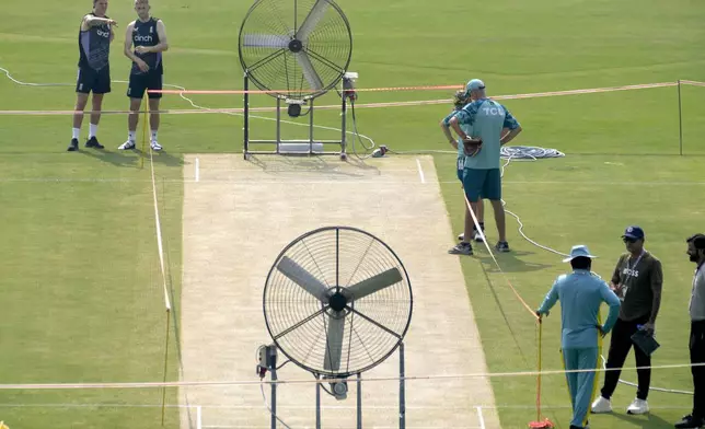 England's Brydon Carse, left, Olly Stone, second left, and Pakistan's coach Jason Gillespie, right, examine the pitch preparing for upcoming third test match between Pakistan and England, in Rawalpindi, Pakistan, Tuesday, Oct. 22, 2024. (AP Photo/Anjum Naveed)