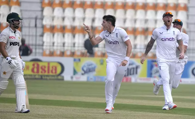 England's Matthew Potts, center, gesture toward Pakistan's Salman Ali Agha, left, as he celebrates after taking Agha's wicket during the second day of the second test cricket match between Pakistan and England, in Multan, Pakistan, Wednesday, Oct. 16, 2024. (AP Photo/K.M. Chaudary)