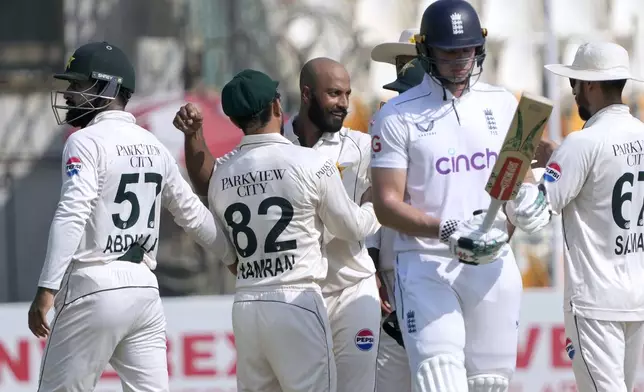 England's Brydon Carse, second right, walks off the field after dismissed by Pakistan's Sajid Khan, center, during the third day of the second test cricket match between Pakistan and England, in Multan, Pakistan, Thursday, Oct. 17, 2024. (AP Photo/K.M. Chaudary)