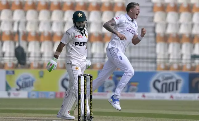 Pakistan's Mohammad Rizwan, center, reacts after he dismissed by England's Brydon Carse, right, during the second day of the second test cricket match between Pakistan and England, in Multan, Pakistan, Wednesday, Oct. 16, 2024. (AP Photo/K.M. Chaudary)