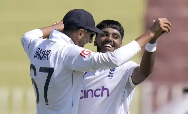 England's Rehan Ahmed, right, celebrates with teammate after taking the wicket of Pakistan's Aamer Jamal during the day two of third test cricket match between Pakistan and England, in Rawalpindi, Pakistan, Friday, Oct. 25, 2024. (AP Photo/Anjum Naveed)